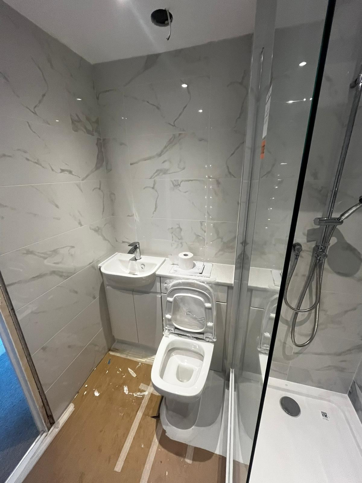 Finished bathroom refit with marble tiling and glass shower screen